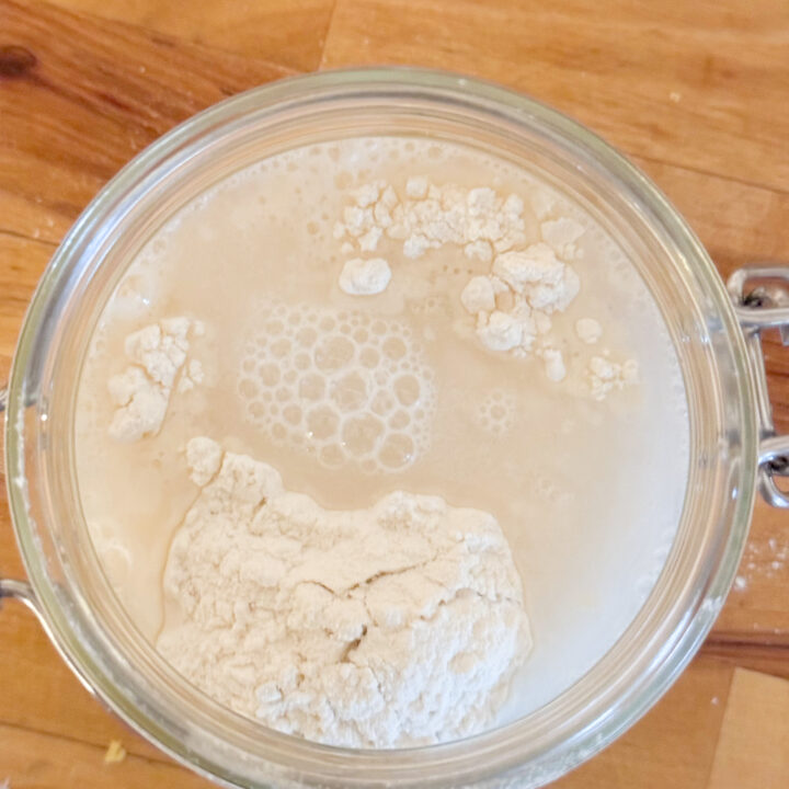 flour and water in a glass jar wood counter background